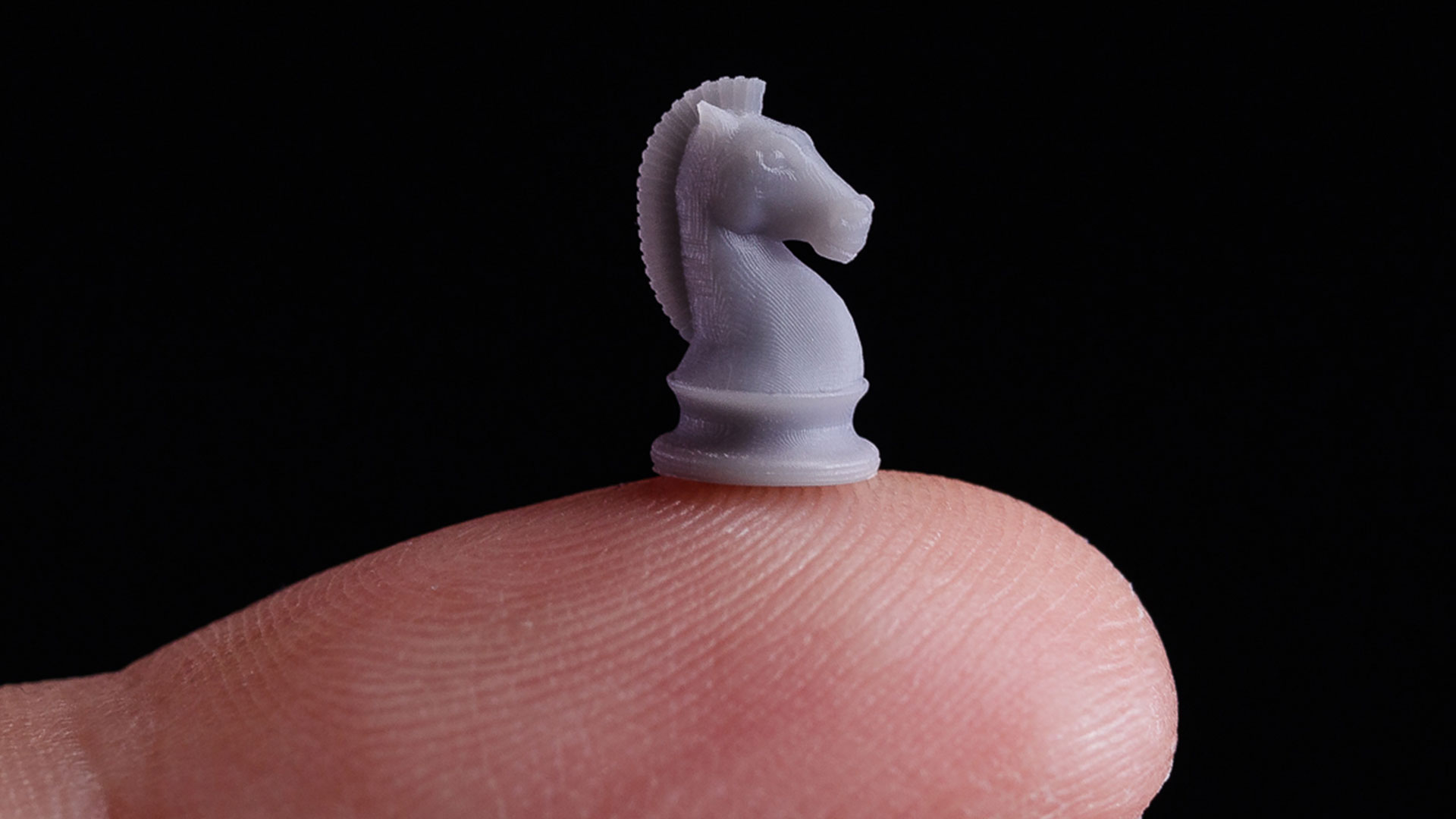 Miniature of horse chess piece on fingertip